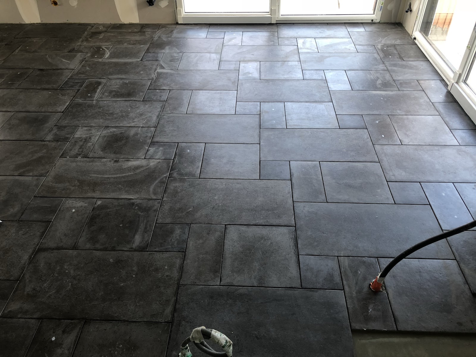 Pose de carrelage grand format aux nuances d'ardoise.